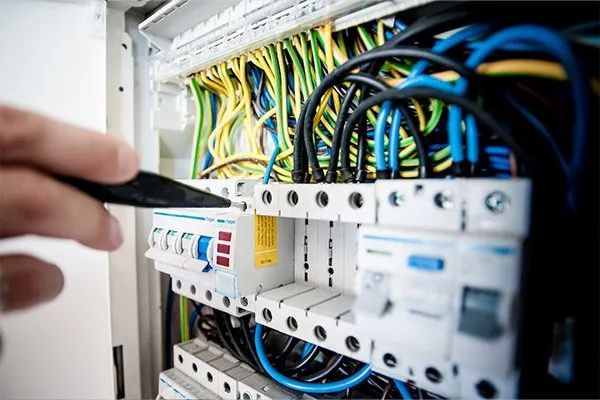 Electrician working inside an electrical breaker panel