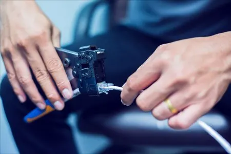 Technician crimping an ethernet network cable