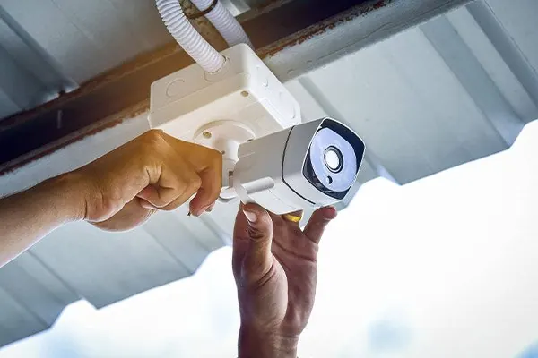 Technician mounting a security camera on a ceiling
