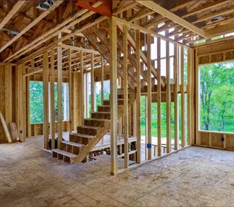 Wood stud framing and staircase inside a home under construction